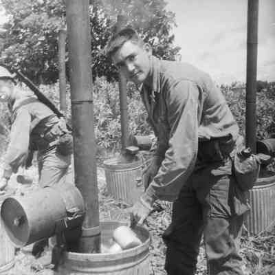Soldiers washing their mess gear in wash cans with immersion heaters