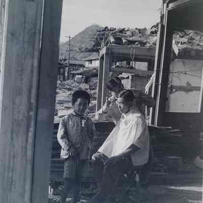 Haircut amid ruined buildings