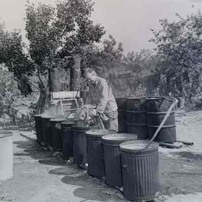 Soldier doing laundry in trash cans