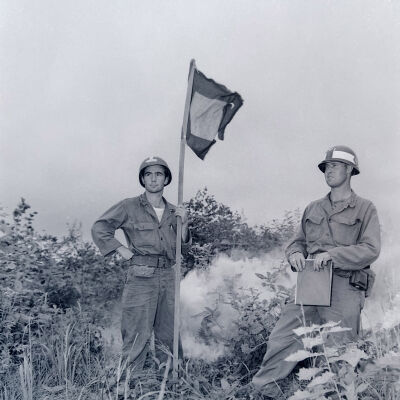 Soldiers standing with signal flag and smoke