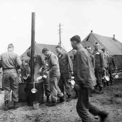 Soldiers dipping mess gear into boiling water station