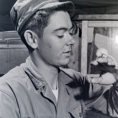 Soldier examining mouse on his hand