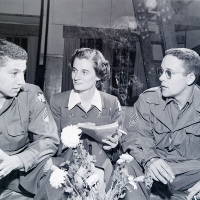 Two soldiers talking with a female Army Services member