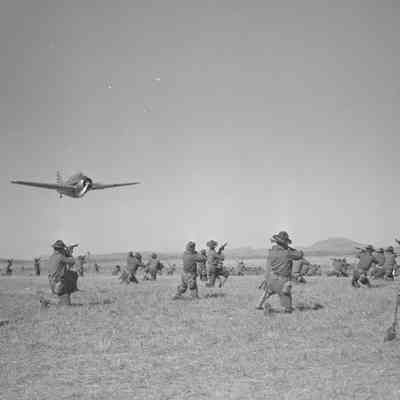 Soldiers aiming their rifles at a low-flying O-47 aircraft