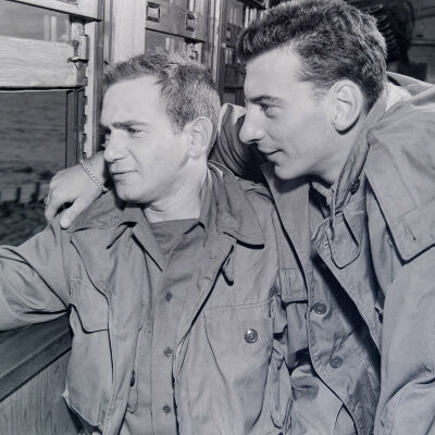 Two soldiers looking out a train-car window