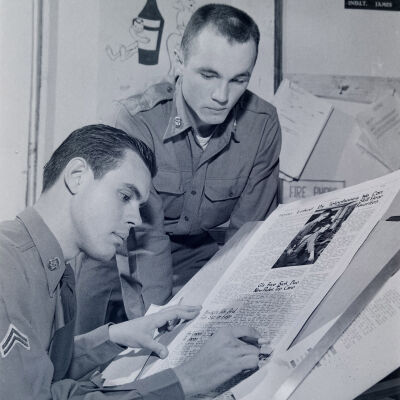 Two soldiers with a newspaper layout board