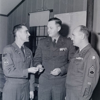 General James Styron and two soldiers conversing in an office