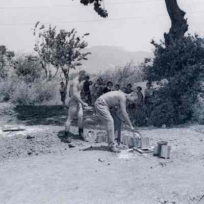 Soldiers emptying mess kit leftovers for Italian children