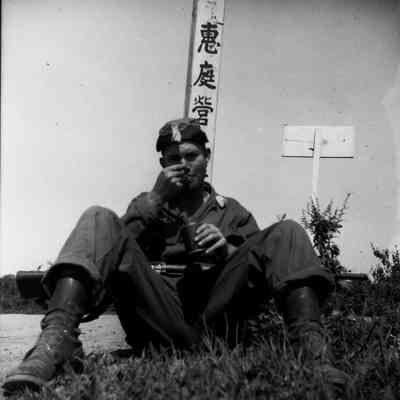 Soldier with his weapon eating c-rations