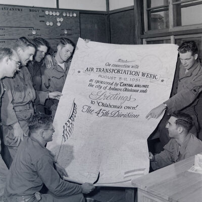 Soldiers holding poster celebrating "Air Transportation Week" sponsored by Central Airlines
