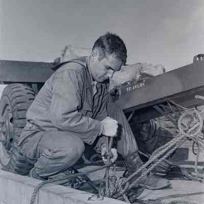 Soldier tying down 105mm howitzer