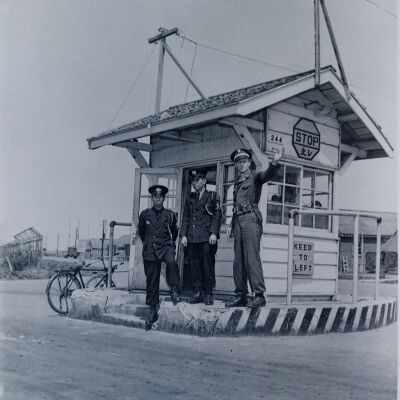 American and Japanese gate guards directing traffic at gate to Camp Crawford