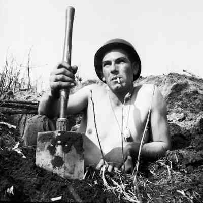 Soldier posing with a shovel in his foxhole