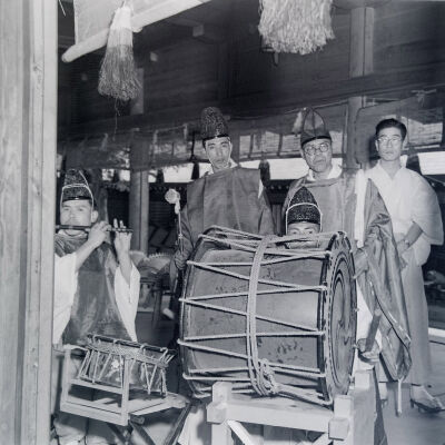 Group of Ainu men in traditional dress playing native musical instruments
