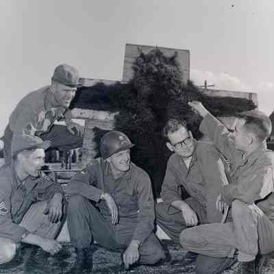 Soldiers posing next to a bear's hide