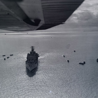 Ship at sea surrounded by landing craft