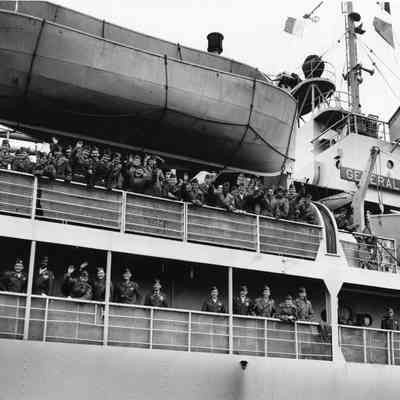 Soldiers waving aboard a ship