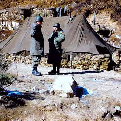 Two soldiers talking in front of tents