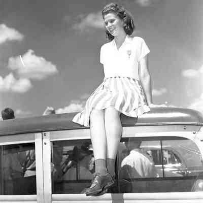Girl sitting on the roof of a car