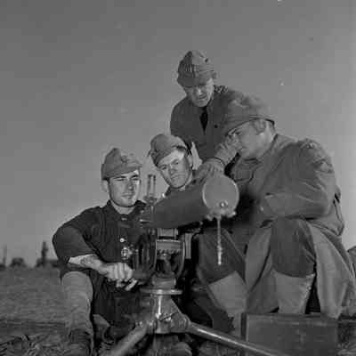 Officer instructing soldiers how to operate a machine gun