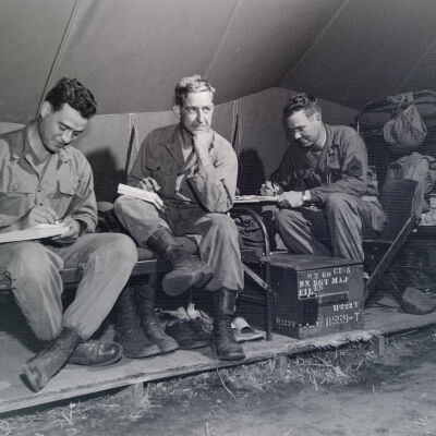 Soldiers in tent writing letters