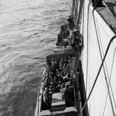 Soldiers climbing down nets into landing craft