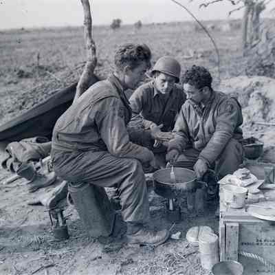 Soldiers, 645th Tank Destroyers cooking over field stove
