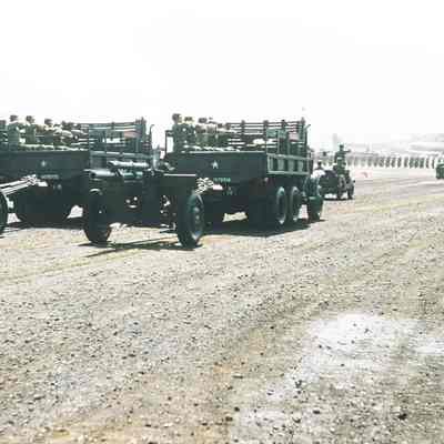 Trucks towing artillery during review