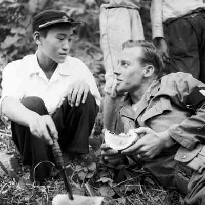 Japanese boy and soldier sharing a melon