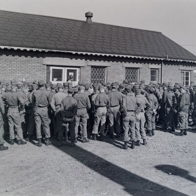 Group of soldiers assembled around a camp building entrance