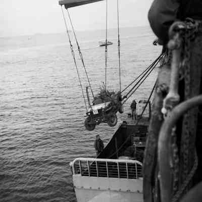 Soldiers loading Jeep into landing craft