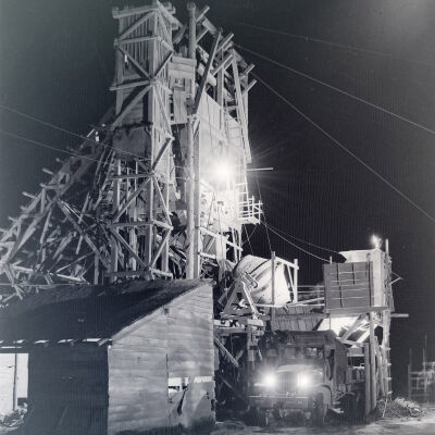 Night photo of a truck being loaded at a concrete plant