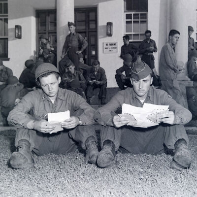 Two soldiers reading letters from home