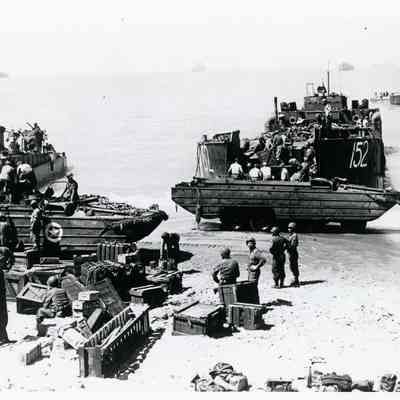 Soldiers unloading equipment onto the beach