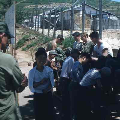 Korean children shining soldier's boots