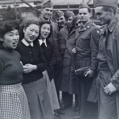 Group of soldiers talking to three Japanese girls