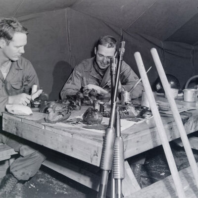 Soldiers in a tent making duck decoys