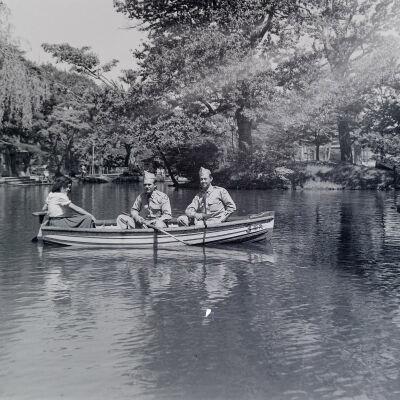 Two soldiers and a civilian woman in a rowboat