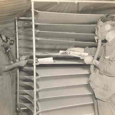 Soldiers developing photos while wearing gas masks