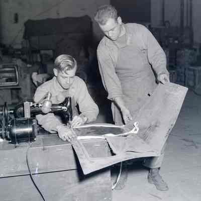 Soldiers patching canvas
