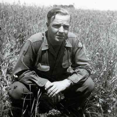 Officer crouching in a field
