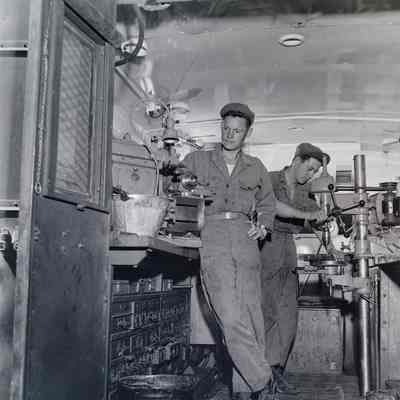 Two soldiers working in a mobile machine shop