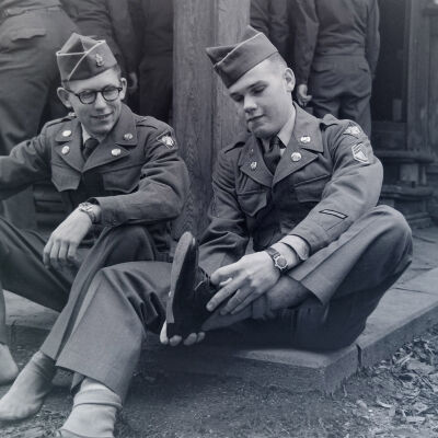 Soldiers removing their shoes at a building entrance