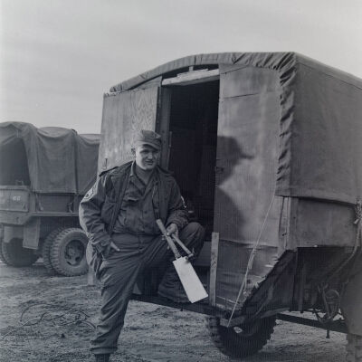 Soldier standing behind a trailer-mounted hut