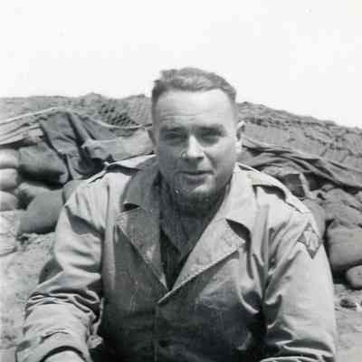 Officer sitting in front of sandbags