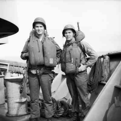 Soldiers on deck wearing life vests and helmets