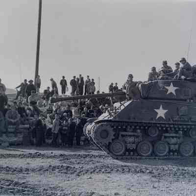 Tank displayed in front of a crowd of civilians