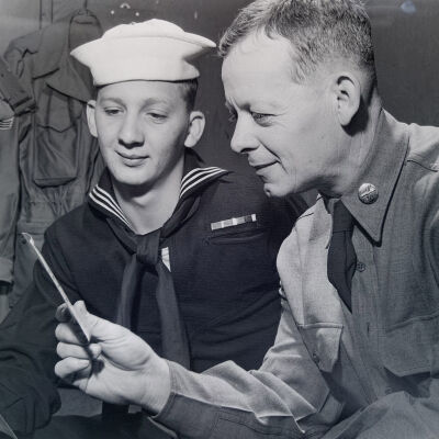 Soldier and sailor examining pictures