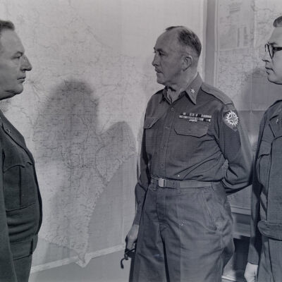 Senior Officers standing in front of a wall map