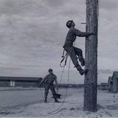 Soldier linemen climbing a pole